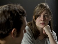Young woman listening to man's testimony at support group