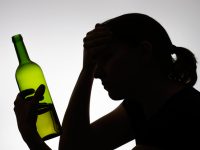 Alcoholic woman's silhouette with a wine bottle