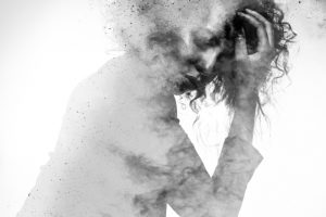 Unhappy woman's form double exposed with paint splatter effect